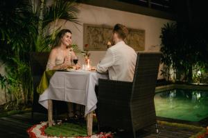 a bride and groom sitting at a table with candles at Villa Raka by Manara in Legian