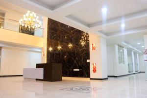 a lobby with a black wall with a chandelier at RK - Inn Premium Suites in Bengaluru