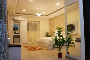 Un dormitorio con una cama y una planta. en RK - Inn Premium Suites, en Bangalore