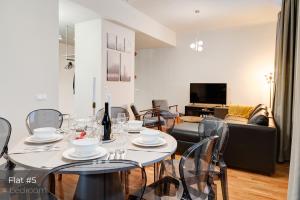 een woonkamer met een tafel met stoelen en een bank bij Dandelion Apartments Stabu in Rīga