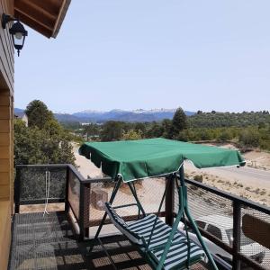 een groene hoes op een balkon met een stoel en een rivier bij Apart hotel Pehuenia in Villa Pehuenia