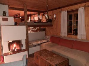 a living room with a couch and a fireplace at Almhütte Chalet HIRSCHFISCH in Bodensdorf