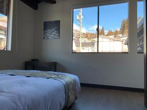 a bedroom with a bed and a large window at Shiro Nozawa in Nozawa Onsen