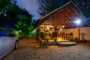 un coche aparcado delante de una casa por la noche en Comfort Beach Hotel, en Arugam Bay