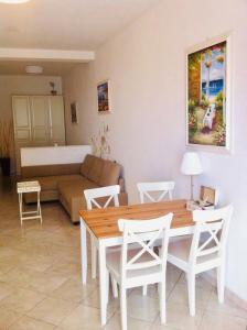 ein Wohnzimmer mit einem Tisch, Stühlen und einem Sofa in der Unterkunft “L’alcova delle Sirene” in Bergeggi