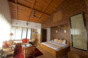 a bedroom with a bed and a living room at Magpie Retreat in Bhīm Tāl
