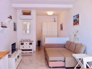a living room with a couch and a tv at “L’alcova delle Sirene” in Bergeggi