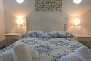 a bedroom with a blue and white bed with two tables at Chalet Cerca de la Playa in Cala'n Bosch