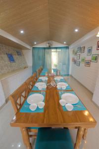 a long wooden table with chairs and plates on it at Magpie Retreat in Bhīm Tāl