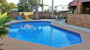 una gran piscina azul en el patio trasero en Royal Palms Motor Inn, en Coffs Harbour