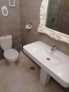 a bathroom with a sink and a toilet and a mirror at Apartamento Carreteria Luxe in Cuenca