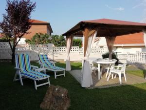 a gazebo with chairs and a table in a yard at Casa La Tablía, un chalet familiar para disfrutar de una escapada en Cantabria in Suances