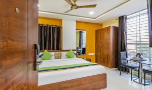 Un dormitorio con una cama y un escritorio y una ventana. en Itsy Hotels D'Comfort Inn, en Hyderabad 18 fotos más