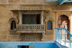 an old building with a balcony and a window at The Blue House in Jodhpur