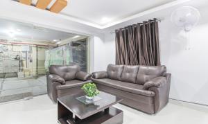 - un salon avec un canapé en cuir et une table dans l'établissement Itsy By Treebo - D'Comfort Inn, à Hyderabad