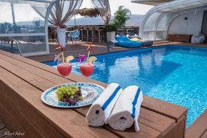 una mesa con bebidas y un plato de comida junto a la piscina en Yosefdream Luxury suites, en Had Nes