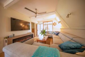 een woonkamer met banken en een flatscreen-tv bij The Lake House in Yungaburra