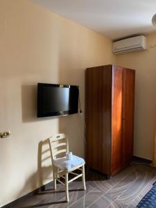 Habitación con silla y TV en la pared. en beb elia, en Nápoles