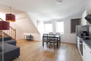 kuchnia i salon ze stołem i krzesłami w obiekcie Skyline Penthouse l LF44 w Wiedniu