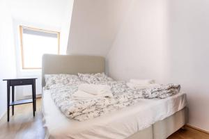 ein Bett mit zwei Kissen auf einem Zimmer in der Unterkunft Penthouse bei Schönbrunn mit Dachterasse! N44 in Wien