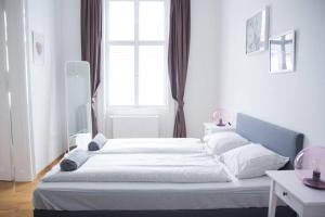 ein großes Bett in einem weißen Zimmer mit Fenster in der Unterkunft Leopold I levestate in Wien