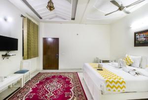 a bedroom with a white bed and a red rug at Hotel Dior Jaipur in Jaipur