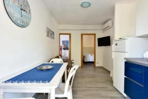 a kitchen and dining room with a table and chairs at Casa Cala Sisine in Santa Maria Navarrese +2 photos