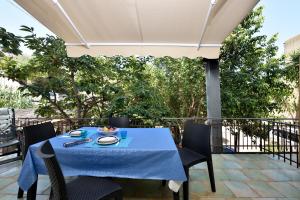 einen Tisch mit einem blauen Tischtuch auf einer Terrasse in der Unterkunft Casa Cala Sisine in Santa Maria Navarrese