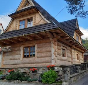 ザコパネにあるDomek Góralski Chata u Słodkiego Zakopaneの花の木造家屋