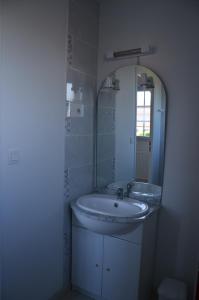 ein weißes Badezimmer mit einem Waschbecken und einem Spiegel in der Unterkunft La Résidence des Fleurs in Lecelles