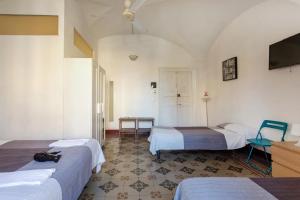 um quarto com duas camas e uma televisão e uma mesa em Da Gianni e Lucia Rooms with bathroom in the city center em Catânia