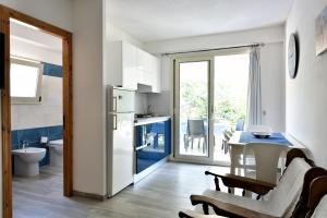 a kitchen with a white refrigerator and a table at Casa Cala Sisine in Santa Maria Navarrese
