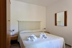 1 dormitorio con 1 cama con toallas en Casa Cala Sisine, en Santa Maria Navarrese