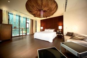 - une grande chambre avec un lit et un canapé dans l'établissement Yen Jim Boutique Motel, à Luodong