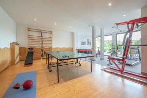 a room with a ping pong table and a gym at Hotel Jonathan in Natz-Schabs