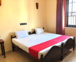 sypialnia z łóżkiem z czerwonym i białym kocem w obiekcie Eestee Rest w Kolombo