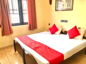 Un dormitorio con una cama con almohadas rojas. en Eestee Rest en Colombo