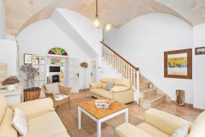 uma sala de estar com mobiliário branco e uma escadaria em CAN CANDELA em Ciutadella