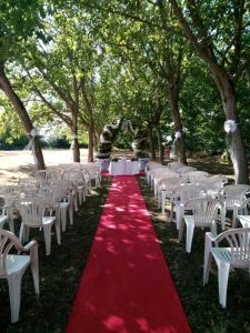 un pasillo con sillas blancas y alfombra roja en Agriturismo Corte dei Landi, en Cadè