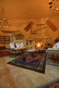 a living room with a couch and a fireplace at Jerveni Cave Hotel in Mustafapaşa