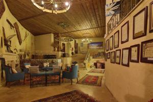 a dining room with a table and blue chairs at Jerveni Cave Hotel in Mustafapaşa