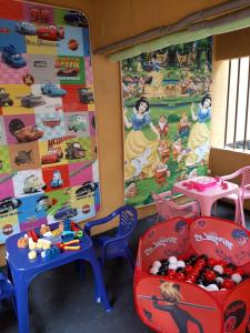 una sala de juegos con juguetes y mesas y una pared con un mural en Aguas Lindas de Itacuruça en Itacuruçá
