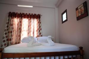 Villa Anandha في تريفاندروم: غرفة نوم عليها سرير وفوط