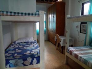1 dormitorio con 2 literas y mesa en Ellens Homestay en Irosin