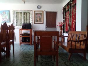 a living room with a dining room table and chairs at Ellens Homestay in Irosin