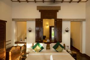 um quarto com uma cama grande e um espelho em Heritage Madurai em Madurai