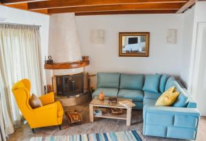 a living room with a blue couch and a fireplace at Athivoli Elegant Apartments in Káto Metókhion