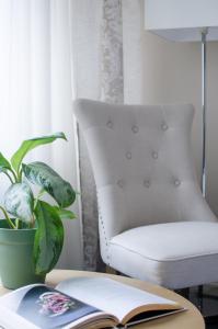 an open book on a table with a chair and a plant at Pine Resort in Saulkrasti