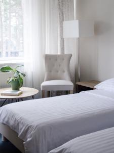 um quarto com uma cama, uma cadeira e uma janela em Pine Resort em Saulkrasti