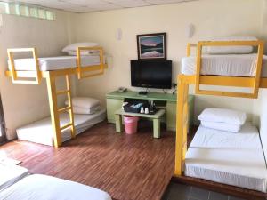 a room with bunk beds and a desk with a computer at Tsengwen Youth Activity Center in Nanxi